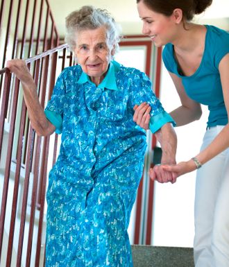 Senior woman getting help down stair from provider Delivery Man with truck
